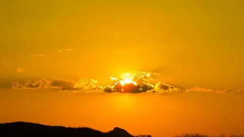 Dramatic golden sunset sky with sun breaking through clouds, casting beauti.. Stock Photos