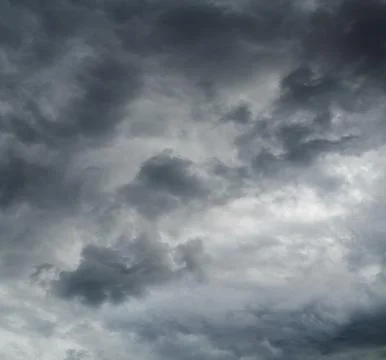 Dramatic gray clouds forming ominous sky during daytime Stock Photos