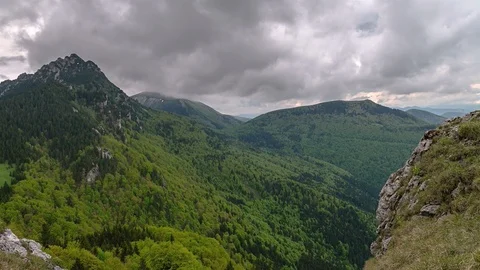 Dramatic grey clouds over green mountains landscape in spring nature Time lapse Video stock 105349475