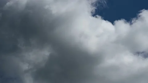 Dramatic grey summer storm clouds move quickly through a sky with blue patches Stock Footage 139651192