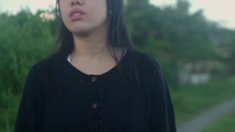 Dramatic handheld close-up shot of young Asian woman with pensive expression Stock Footage 294667911