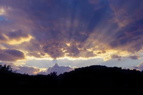 Dramatic heavenly cloudscape at sunset and silhouette of hillrange Stock Photos