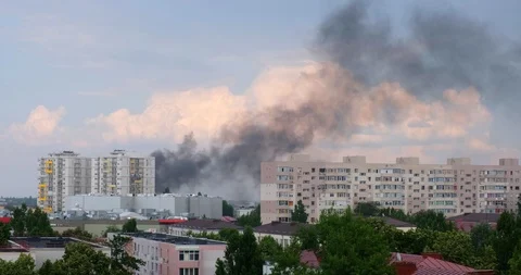 Dramatic heavy smoke cloud from apartment building, with white clouds behind it. Stock Footage 112675373