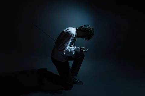 A dramatic hero with a sword in his hands, suffering from defeat and injury, Stock Photos