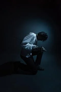 A dramatic hero with a sword in his hands, suffering from defeat and injury, Foto stock