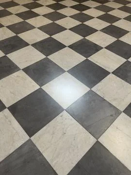 A dramatic, high-contrast close-up of a classic checkerboard floor pattern,.. Stock Photos