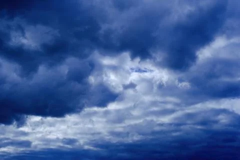 Dramatic high deep blue sky with fluffy clouds, cloudscape in stormy weather Photos