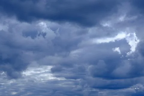 Dramatic high deep blue sky with fluffy clouds, cloudscape in stormy weather Stock Photos