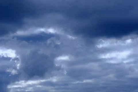 Dramatic high deep blue sky with fluffy clouds, cloudscape in stormy weather Stock Photos