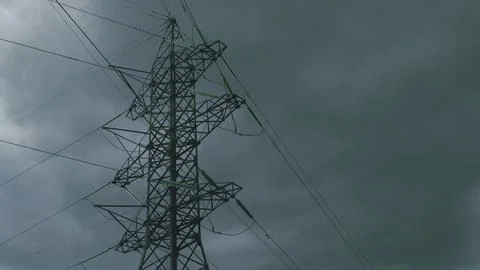 A Dramatic High Voltage Power Line Silhouetted Against the Foreboding Dark Sky B Stock Photos