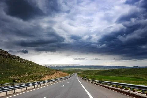 Dramatic highway scene with storm clouds over open countryside landscape 스톡 사진