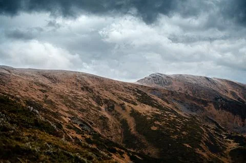 Dramatic Hills Under Cloudy Sky Stock Photos