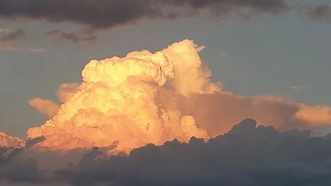 Dramatic huge thunderclouds at sunset, great detail, orange glow at golden hour Vídeo Stock 265126047