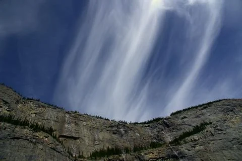 Dramatic Ice-Like Cloud Trails Streaking Across a Deep Blue Alpine Sky Stock Photos