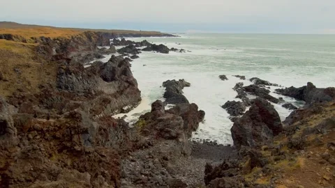 Dramatic Icelandic Coastline with Volcanic Cliffs and Crashing Waves Stock Footage 320229246