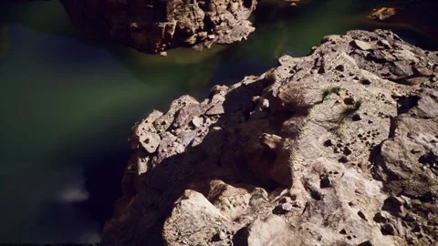 Dramatic illumination highlights rocky canyon edges and reflective water Stock Footage 342430192