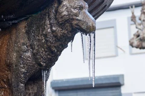 Dramatic image of a statue of a frozen wolf with an icicle in the town of Pio Stock Photos