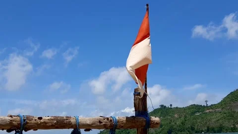 Dramatic Indonesian Flag Waving Strong Wind Blue Sky Green Hill Background Stock Footage 323077380