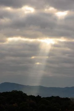 A dramatic interplay of light and shadow across a vast, overcast sky Stock Photos