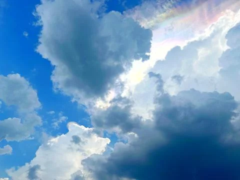 Dramatic iridescent clouds with rainbow colors in blue sky Stock Photos