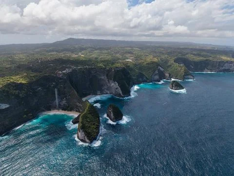 Dramatic jagged coastline with waves, turquoise waters crashing against rocky Stock Photos