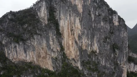 Dramatic karst mountain rock face, rugged texture, rising aerial view Stock Footage 146015559