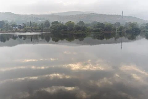 Dramatic lake water reflection of cloud with mountain surrounding at morning Stock Photos