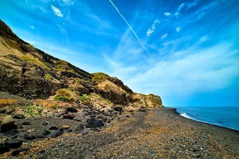 Dramatic landscape of black volcanic beach and blue sky and clouds Stock Photos