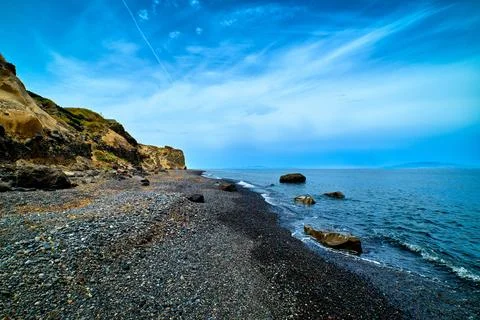 Dramatic landscape of black volcanic beach and blue sky and clouds Stock Photos