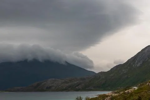 Dramatic landscape of coastal scene with thick clouds on a mountain. Stock Photos