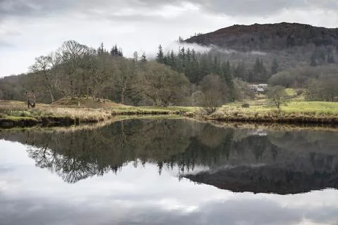 Dramatic landscape image looking across River Brathay in Lake District toward Stock Photos