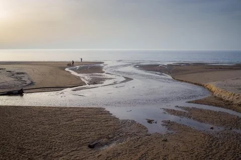 Dramatic landscape with a river winding through a sandy expanse towards the s Stock Photos
