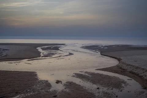 Dramatic landscape with a river winding through a sandy expanse towards the s Stock Photos