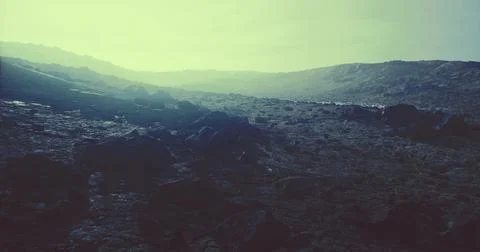 Dramatic landscape with rocky terrain under a hazy sky at dusk Stock Illustration