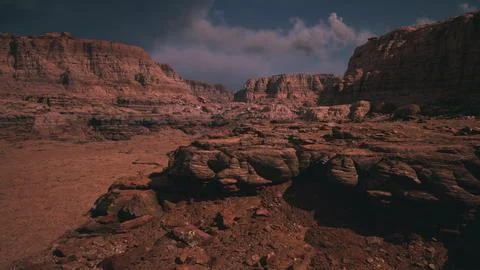 Dramatic landscape of rugged cliffs and barren terrain under a cloudy sky Illustrazione stock
