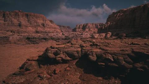 Dramatic landscape of rugged rock formations under a cloudy sky at dusk Illustrazione stock