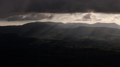 A dramatic landscape shows sun rays cutting through a cloudy sky Stock Footage 301382761