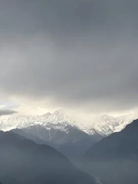Dramatic Landscape of Snow-Capped Mountain Peaks under a Moody Overcast Sky Stock-Fotos