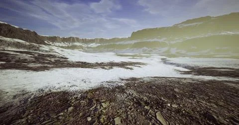 Dramatic landscape of snow covered terrain near rugged mountains at dusk Stock Illustration