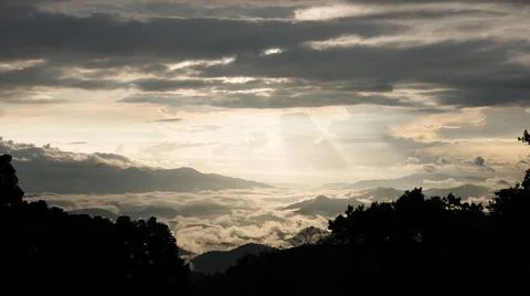 Dramatic landscape of sunlight through cloudy sky at sunrise. Stock Photos