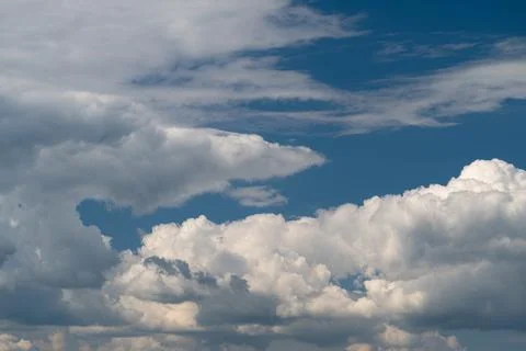 Dramatic layered cumulus clouds against deep blue sky Stock Photos