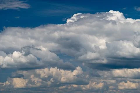 Dramatic layered cumulus clouds under deep blue sky Stock Photos