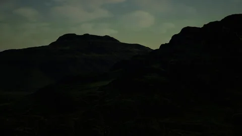 Dramatic layered scene with mosscovered hills beneath cloudy sky Stock Footage 339616532