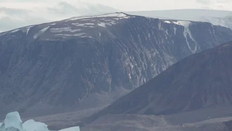 Dramatic Light Across Arctic Mountain Slopes in Uummannaq Greenland 库存影片 345629227