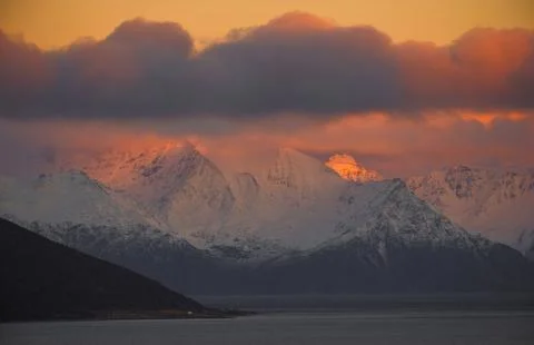 Dramatic light and clouds over mountain peaks around Tromso northern norway Stock Photos