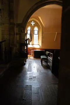 Dramatic Light and Shadow in Church Aisle with Window and Font Niche Stock Photos