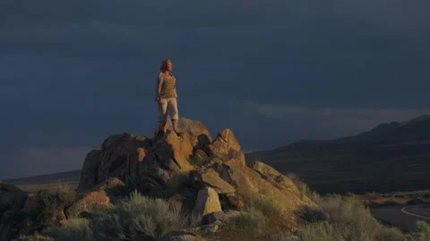 Dramatic light and woman in ms, in dark desert sky at sunset, 4k Stock Footage 274686299