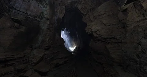 Dramatic light breaking through a cave opening at dusk in a secluded location Stock Footage 320141237