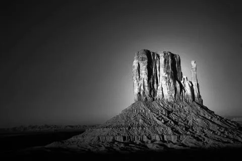 Dramatic light of dawn striking a rock formation in monument valley Stock Photos