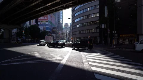 Dramatic light during evening of cars passing by zebra crossing road near Umeda Stock Footage 98991994